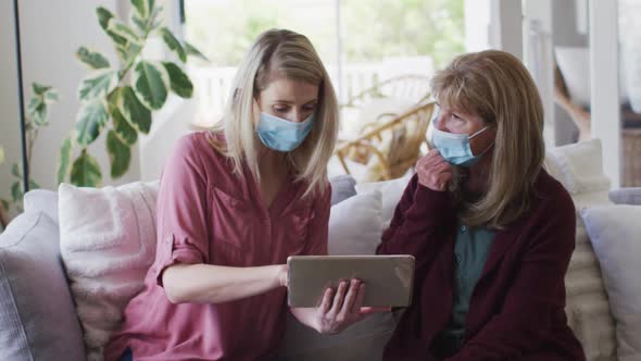 Mother and daughter using digital tablet at home