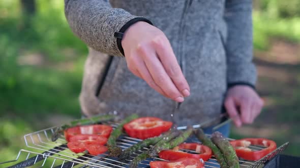 Making Grilled Vegetables  Salting Asparagus and Red Pepper on a Charcoal Grill