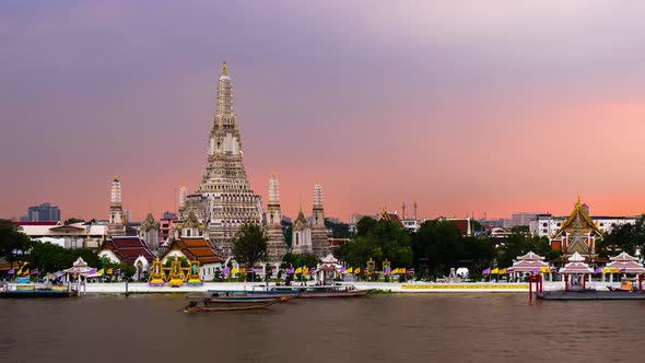 day to night time lapse of Wat Arun Temple with Chao Phraya river in Bangkok, Thailand