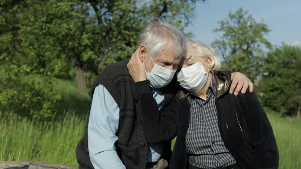 Senior Couple in Medical Masks During COVID-19 Coronavirus Quarantine in Park