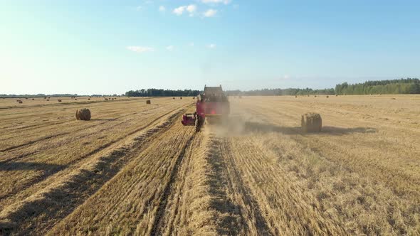 Farmer In Combine Harvester Collect Of Wheat Crops On Rural Field Aerial View