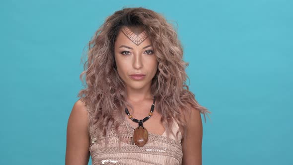 Portrait of Warlike Tribal Woman with Traditional Pattern or Tattoo on Face Looking Strictly with