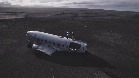 Awesome Drone Shot Of Two Tourists on Top of the Solheimasandur Plane Wreck