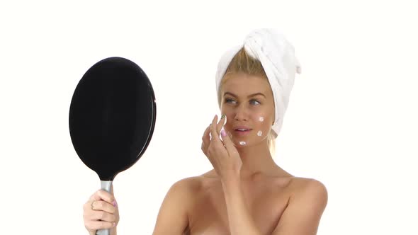 Smiling Young Woman Applying Face Cream, Bathroom