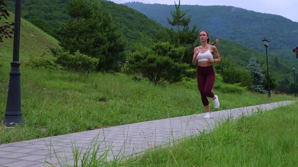 Sportswoman Jogging in Scenic Green Park