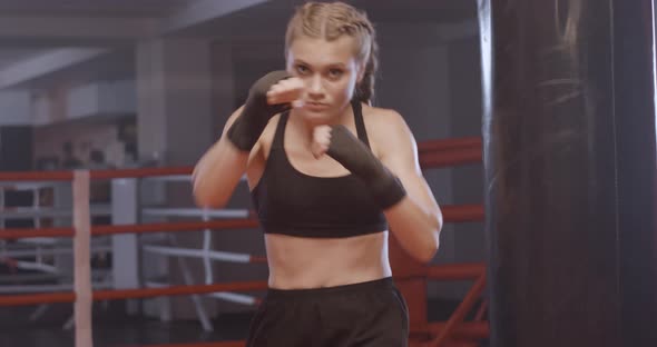 Female Fighter Trains His Punches, Training Day in the Boxing Gym, the Girl Trains a Series of