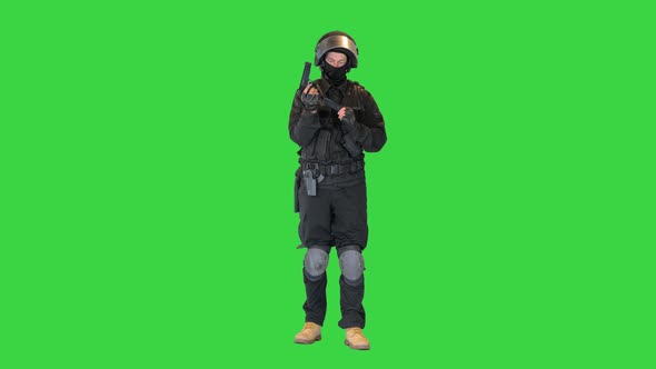 Police Tactical Officer Checking His Hand Gun and Folding Hands on a Green Screen Chroma Key