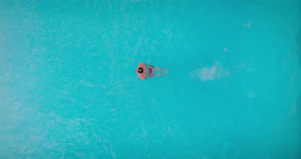 View From the Top As a Man Dives Into the Pool and Swims