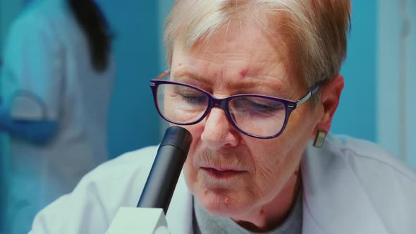 Close Up of Senior Scientist Making Research Using Microscope