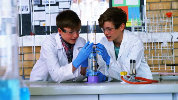 School boys doing chemical experiment in laboratory at school