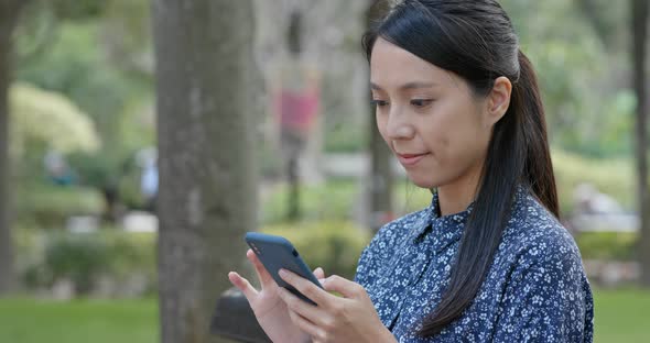 Woman use of mobile phone in the park