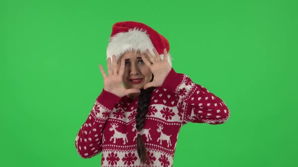 Portrait of Sweety Girl in Santa Claus Hat with Fear and Horror Looking Forward. Green Screen