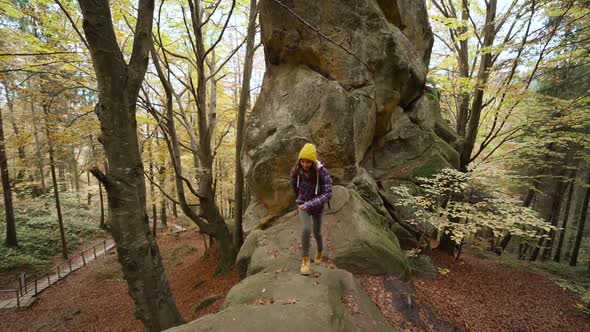 Travel in Ukraine Woman Hiker with Backpack Climbs Up a Huge Stone with Green Moss