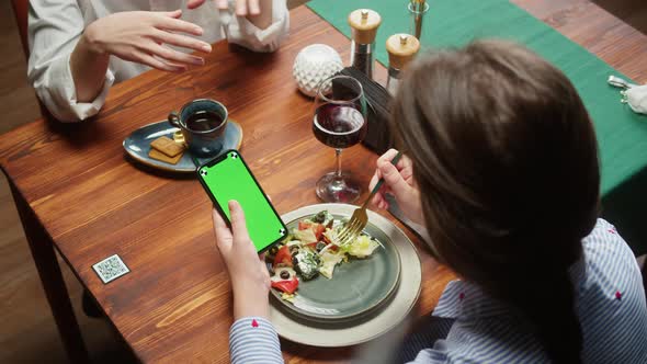 Woman Using Smartphone with Chroma Green Screen and Eating Salad