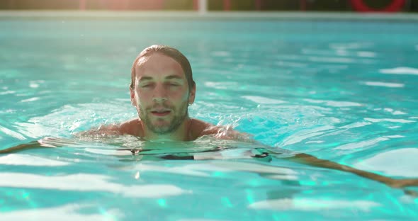 Man Into Water Relaxing in Swimming Pool in Sunny Day