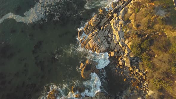 Aerial wide top-down drone shot of primeval massive natural sandstone rock formations and coastal su