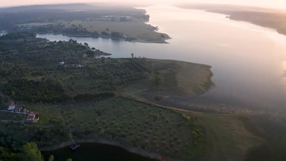 aerial view of lake in ponte de sor with huge sunrise reflections 4k Drone, Alentejo, Portugal.