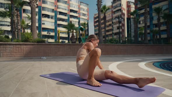 Sporty Woman Doing Workout with an Animal Flow Move Outdoor Near the Pool