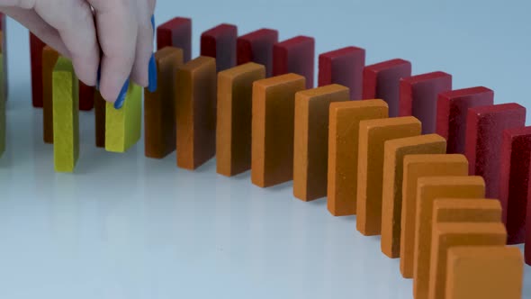 Line up of Dominoes in Rainbow Falling Colors with LGBT Colors of a Hand