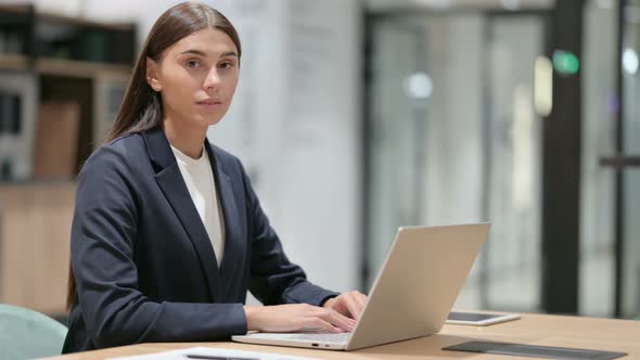 Serious Businesswoman with Laptop Looking at the Camera 