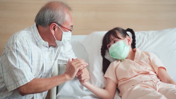 Asian young little girl kid wear mask lying on bed in recovery room from curing the COVID19 pandemic