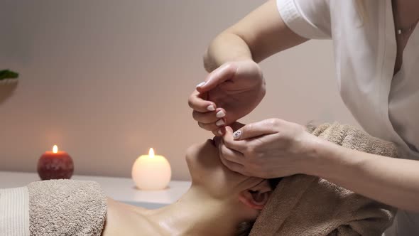Relaxing massage. Woman receiving head massage at spa salon, side view.