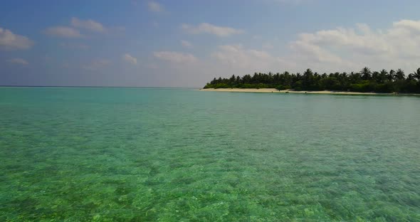 Wide angle drone travel shot of a sunshine white sandy paradise beach and blue water background