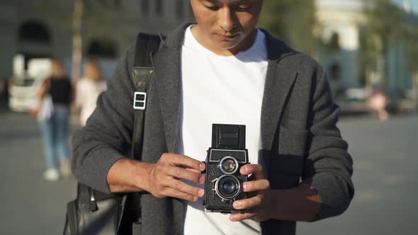 Real Time Portrait Shot of a Young Asian Man Taking a Picture on an Old Camera. Moscow Is the