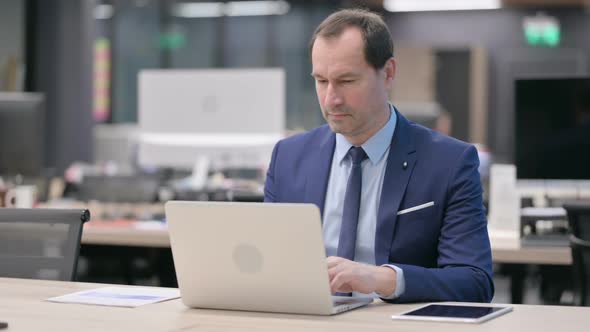 Businessman Working on Laptop in Office