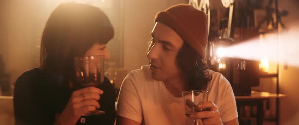 Young couple kissing each other with wine glasses in hands