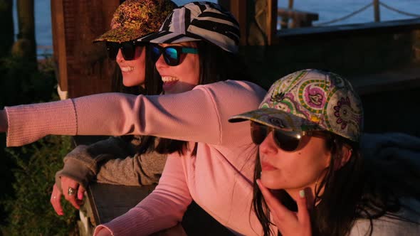 group of cheerful women looking at the sea with cap, pichilemu, punta de lobos, surf beach.Chile.