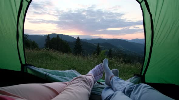 A Loving Couple is Resting in the Mountains They are Sitting in a Tent and Talking