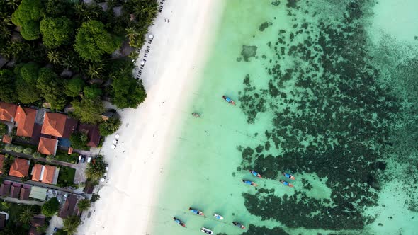 Rural buildings on the beachfront of a paradisiacal Pattaya beach in Thailand. Aerial