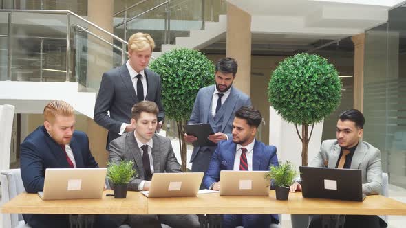 Business People at Negotiating Table in the Office with Laptops