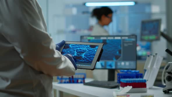 Close Up of Scientist in Lab Coat Working Holding Tablet