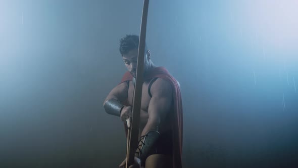 Shirtless Wet Spartan Raising Bow with Arrow.