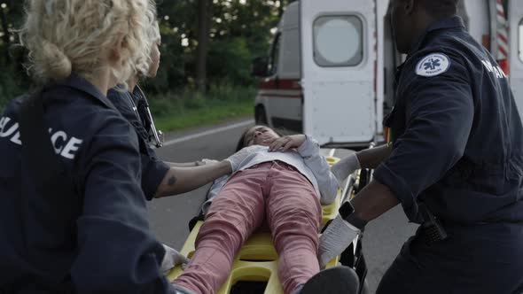 Multicultural Paramedics Carrying Injured Child on Stretcher