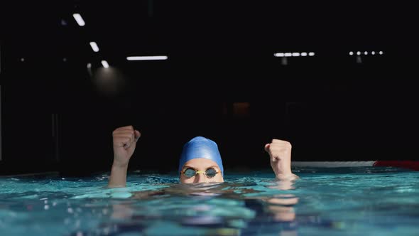 Swimmer Jumping Up and Cheering Raising Arms in the Pool