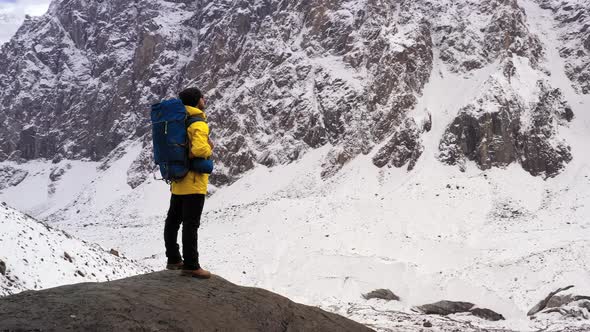 Tourist on Mountain Top. Sport and Active Life. Hiker with Backpack Standing on Top of a Mountain