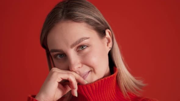 Flirting woman wearing red sweater looking at the camera