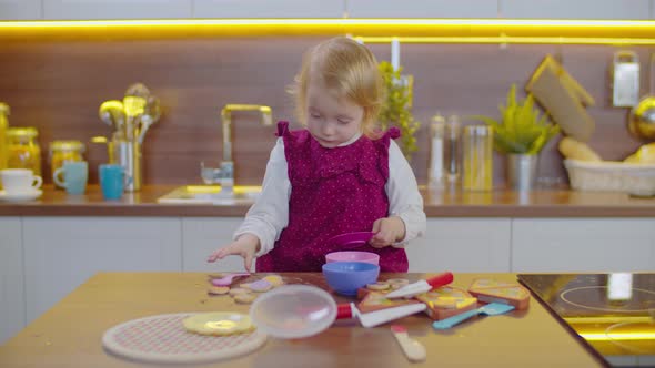 Cute Toddler Girl Playing with Plastic Tableware