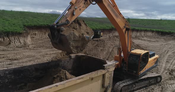 A Crawler Tractor Fills The Ground With A Bucket Into A Truck