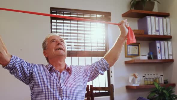 Senior man exercising with resistance band