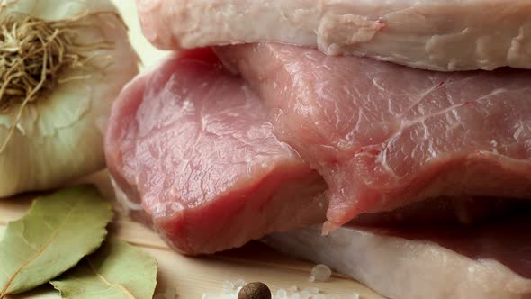 Fresh pork with ingredients for cooking on wooden board