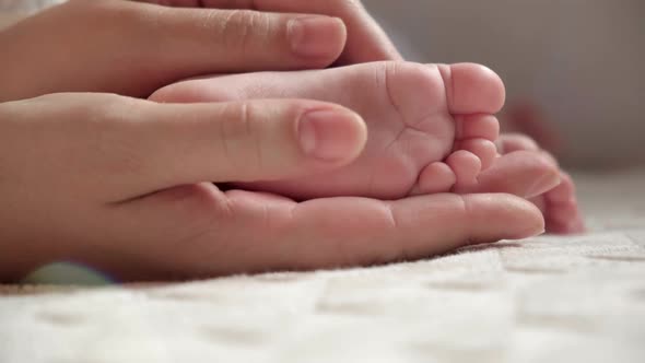 Mother Holding Baby Feet in Hands