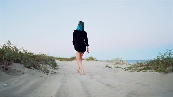 Woman with Unusual Blue Dyed Hair Walking Barefoot on Sandy Beach Alone. Slow Motion. Girl Walks