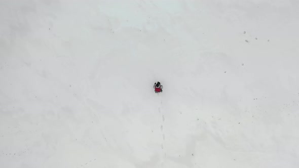 Aerial View: Human Walk By Snowy Desert. View From the Top.