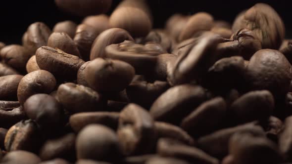 Nice Falling Coffee Beans on Rotating Coffee Beans. Cinematic Footage of Roasted Coffee Extreme