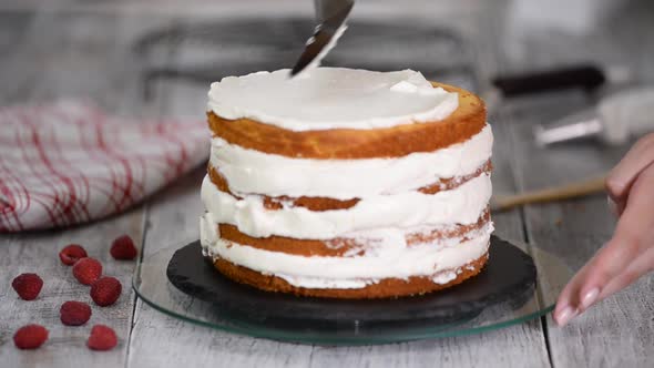 Close-up of pastry covered with butter cream sponge cake. Cream in a pastry bag