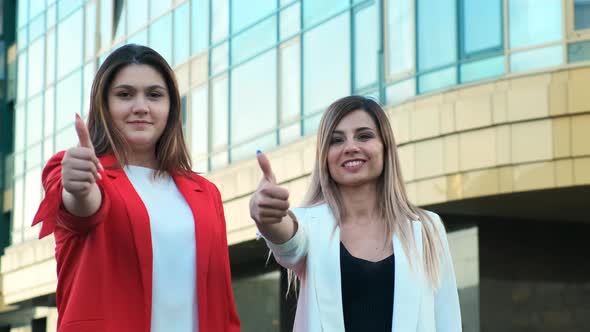 Two Business Women Show Thumbs Up Sign. Successful Completion of the Working Day, Successfully